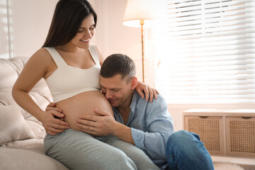 Canvas Print - Man touching his pregnant wife's belly at home