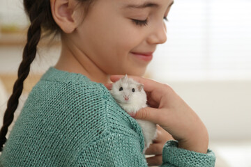 Sticker - Little girl with cute hamster at home, closeup