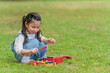 © Mongkolchon - mixed race little girl have fun playing musical toy on grass lawn in park