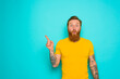 Man with yellow t-shirt and beard is shocked about something