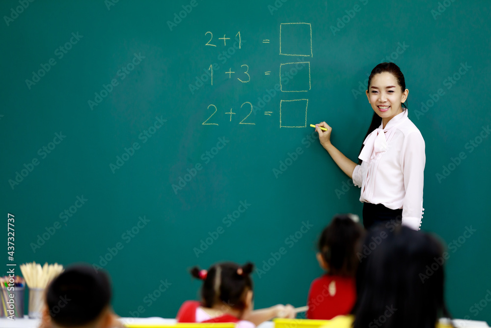 Female Tutoring Math Portrait shot of Asian beautiful female mathematic tutor standing ...