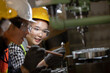 © nikomsolftwaer - Asian Group industrial manager man demonstration and training mechanic worker woman  operating industrial lathe machine. Industry and engineering people technology concept .