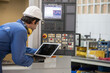 © nikomsolftwaer - man Lathe worker in production plant drilling at machine on the factory. Industrial engineer worker holding laptop Inspect workpieces