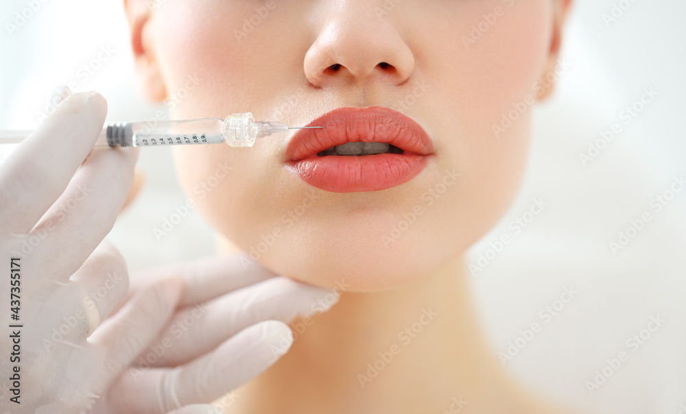 Woman receiving beauty injection in lips - obrazy, fototapety, plakaty 
