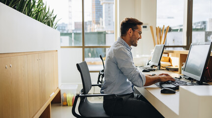 Smiling young man working at his desk