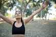 © izzetugutmen - beautiful young woman in sportswear hands up and getting fresh air