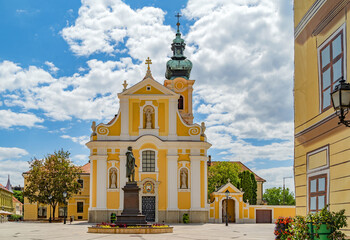 The Carmelite church and the sculpture of Kisfaludy at the Vienna's Gate Square in the downtown of Gyor, Hungary.