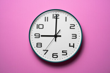 Wall Mural - Retro clock at 9 o' clock on pink table background, vintage style