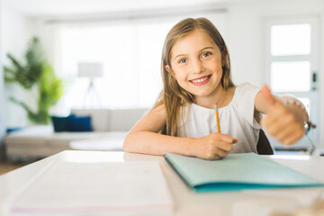 pretty little girl enjoys learning and doing some homework