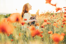 Young Woman Playing Ukulele In Red Poppy Field.