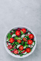 Wall Mural - Green salad bowl with tomatoes, cucumbers, red onions, radicchio and fresh lettuce.