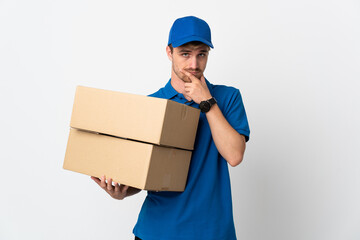 Young delivery blonde man isolated on white background thinking