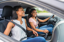 Young Black Teenage Driver Seated In Her New Car With Her Mother