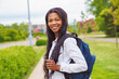 © Louis-Photo - A black adult woman university student on campus with backpack