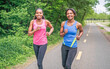 © Louis-Photo - Mother and teen daughter running in green park in summer time