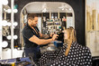 © SuperStock - Stylist cutting young womans hair in polka dot cape at boutique salon