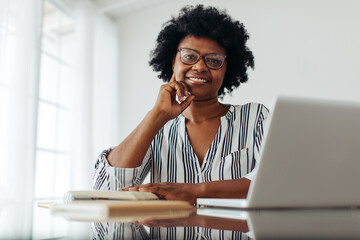 Happy woman sitting at desk at home