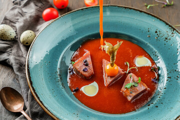 Wall Mural - Grilled tuna with pepper and tomato sauce in plate on wooden background. Healthy food, seafood cuisine, close up