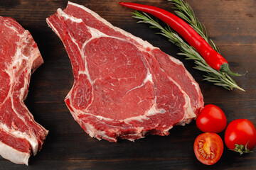 Wall Mural - Raw rib eye steak on brown wooden board