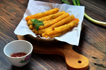 Cheese potato sticks with celery, on an exotic wooden table, national french fry day illustration