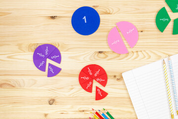 Wall Mural - Colorful fractions in mathematics on the open notepad on wooden table. Interesting math for kids. Education, back to school concept	