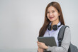 © EduLife Photos - Portrait of a young Asian woman student in uniform holding tablet in smart and happy pose in university or college classroom. Youth girl student and tutoring education with technology learning concept