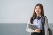 © EduLife Photos - Portrait of a young Asian woman student in uniform holding tablet in smart and happy pose in university or college classroom. Youth girl student and tutoring education with technology learning concept