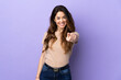 © luismolinero - Woman over isolated purple background pointing front with happy expression