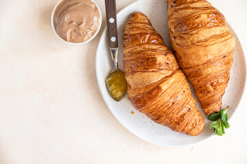 Wall Mural - Croissants with jam and chocolate cream, light concrete background. Top view.