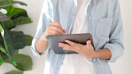 Wall Mural - close up of man hand writing on digital tablet while working at home, online study, telecommunicatio