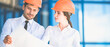 © realstock1 - The two engineers look to the project plan on the background of the building
