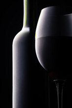 Silhouette Of Green Bottle And Red Wine Glass. Black Background.