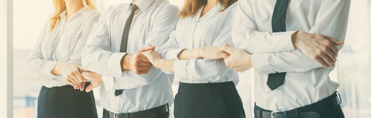 Wall Mural - The smile business people hold hands on the sunny background