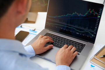 Poster - close-up young businessman statistic graph of stock market financial indices analysis on a laptop an