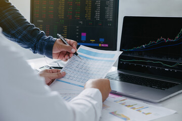 Close-up of young business team Investment Trading discussion and analysis finance market graph stock in office while man pointing on the data presented in the chart .Investment and stock concept