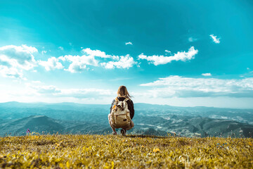Wall Mural - Hiker with backpack relaxing on top of a mountain and enjoying valley view  - Traveler woman exploring outdoor - Sport and travel concept