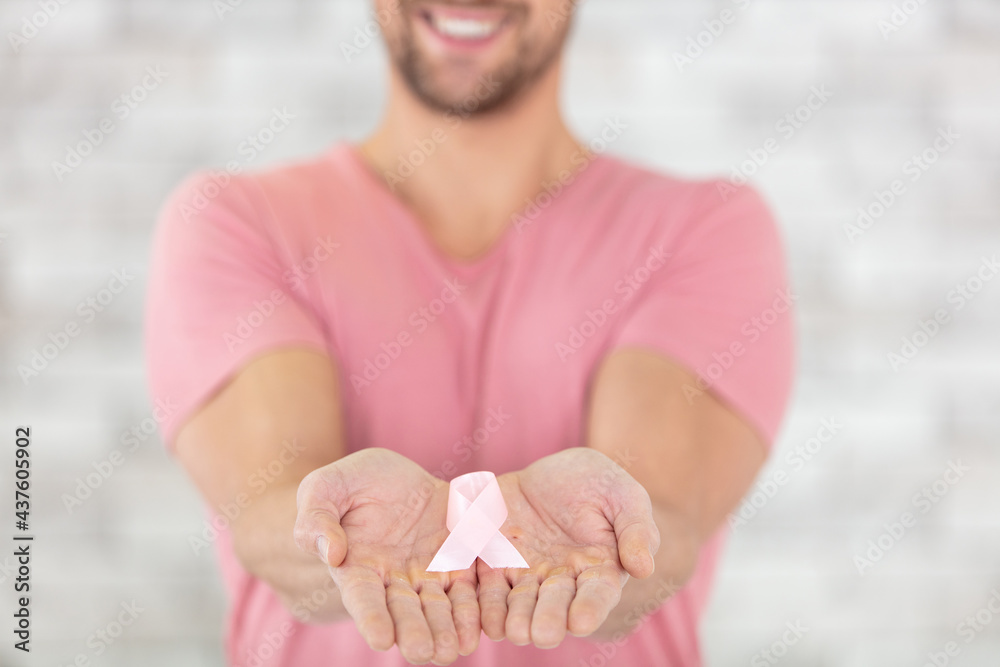 hands with pink ribbon symbolising the fight against breast cancer - obrazy, fototapety, plakaty 
