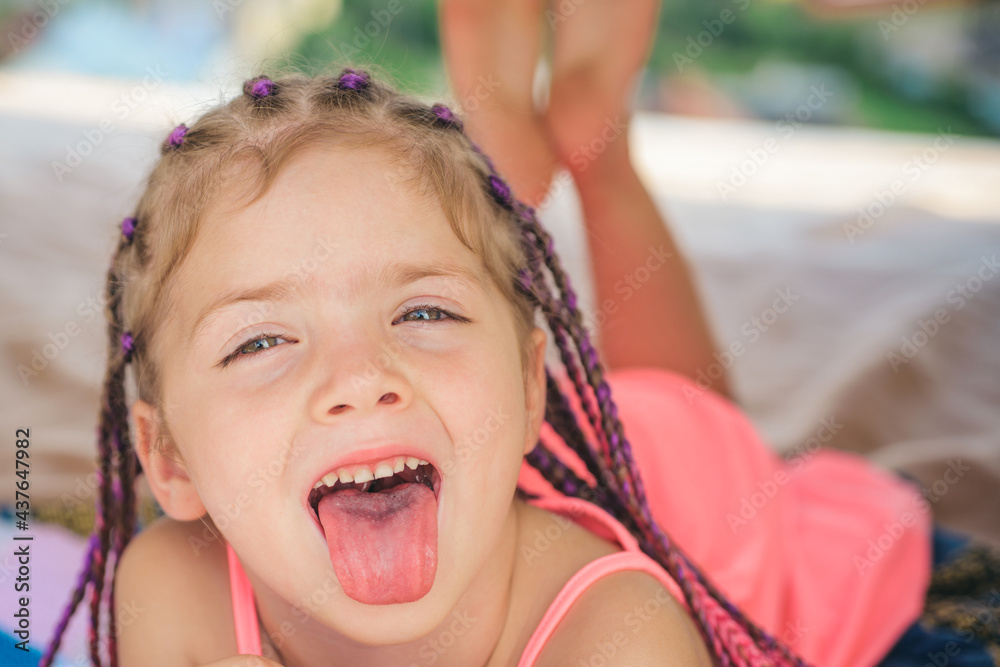 Girl tongue out. Having fun outdoors. Campground. Smiling adorable kid in camp. Child playing in tent. Kids camping. - obrazy, fototapety, plakaty 
