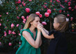© Aleksandra Iarosh - mom kiss hands her little daughter against the background of a rose bush