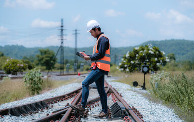 Wall Mural - Engineer under  inspection and checking construction process railway switch and checking work on railroad station .Engineer wearing safety uniform and safety helmet in work.