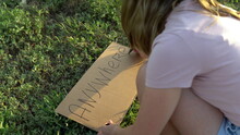 The Girl Writes Anywhere With A Marker On Cardboard. Hitchhiking. Trying To Stop The Car With A Sign
