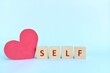 © sulit.photos - Self love and care concept. wooden blocks typography with big red heart shape cutout.