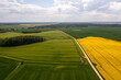 aerial view to countryside with road, green and yellow agricultural fields, forests