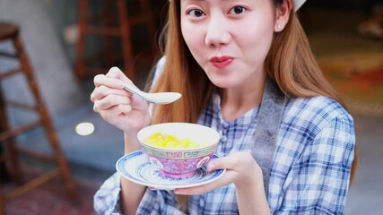 Wall Mural - Asian Young woman  Eating Traditional Asian Street Food  at   Market Bangkok city.Close up of pretty woman eating thai street food .