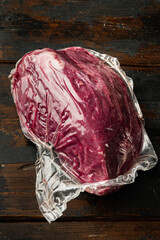 Wall Mural - Beef meat cut in vacuum, on old dark  wooden table background