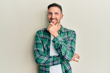 Poster - Handsome man with beard wearing casual clothes looking confident at the camera with smile with crossed arms and hand raised on chin. thinking positive.