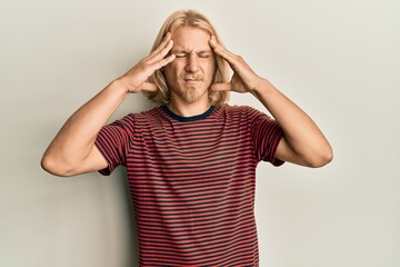 Poster - Caucasian young man with long hair wearing casual striped t shirt with hand on head, headache because stress. suffering migraine.