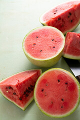 Wall Mural - Sliced ripe red watermelon on light green surface