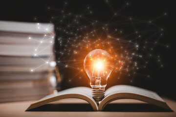Thinking and creative concept, Light bulb on the Book and light bulb style bokeh vintage dark background,Concept The idea of reading books, knowledge, and searching for new ideas.