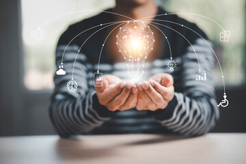 Poster - Business hand holding light bulb and working with icon Business with computer on the desk, Creativity and innovation are keys to success.Concept of new idea and innovation with Brain and light bulbs